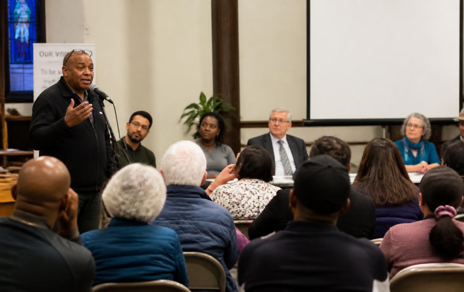 Neighbors gathered at a community meeting in a church hall